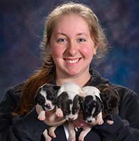 Gabby McClintock with 2 puppies